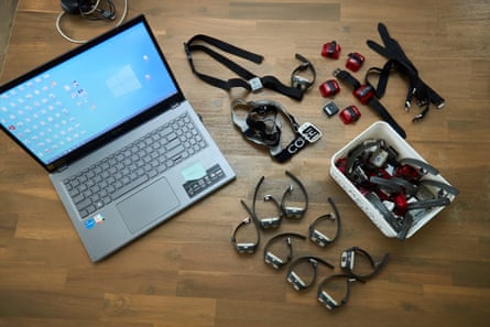 A laptop sits next to a variety of wearable monitors.