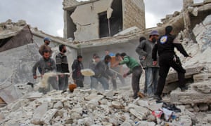 Rescuers and civilians inspect a destroyed building in the Syrian village of Kfar Jales following airstrikes by Syrian and Russian warplanes.