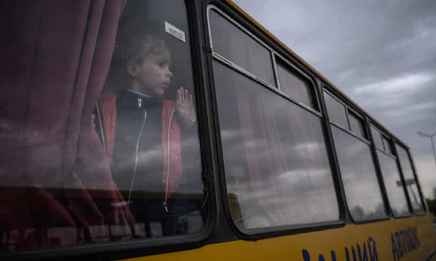 A girl looks out from a bus as families from Russian-occupied territories in the Zaporizhzhia region arrive in a humanitarian convoy at a registration and processing centre for internally displaced people.