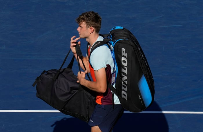 A disappointed looking Jack Draper leaves the court after retiring injured.
