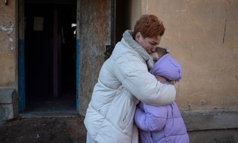 A woman hugs her daughter in front of an apartment building after their flat was damaged by recent shelling in Donetsk, Russian-controlled Ukraine.