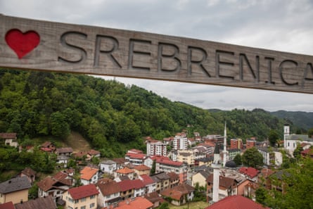 A sign for Srebrenica in front of houses and buildings in the town.