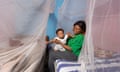 Tony-Jason, eight months, and his mother, Melissa, at home in Soa, near Yaoundé, Cameroon, with the mosquito nets in their bedroom.