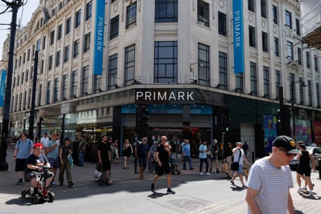 Shoppers pass by a branch of Primark during a heatwave in Manchester, on 25 June.