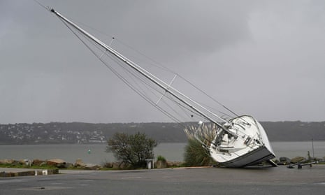 A beached modern yacht, tilted over on its side on what appears to be a stretch of tarmac