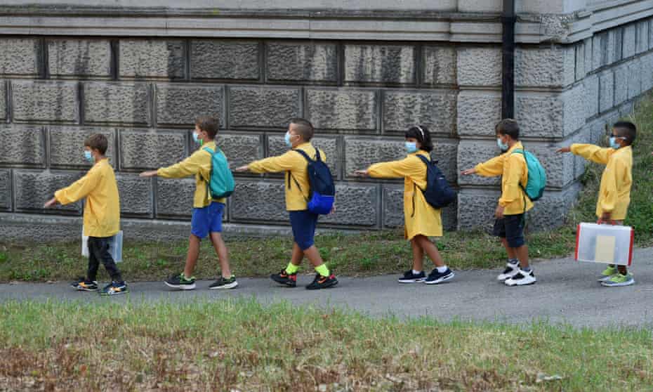 Students keeping their distance arrive at elementary school in Milan, Italy, for the first day of term.