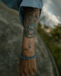 The Venezuelan coat of arms and squiggly signature of Hugo Chávez are tattooed on an arm