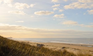 Dunes, beach and sea at the coast of Holland during a summer evening