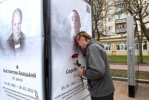A man cries at a memorial poster depicting a fallen soldier