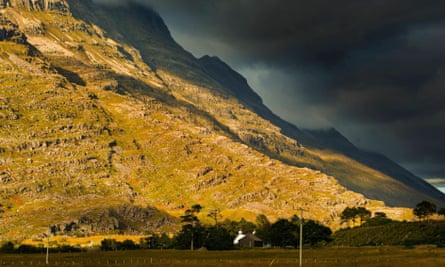 Liathach,  one of the Torridon hills, Wester Ross and a farm at the foot of a mountain in a plain heath seen at sunset in autumn