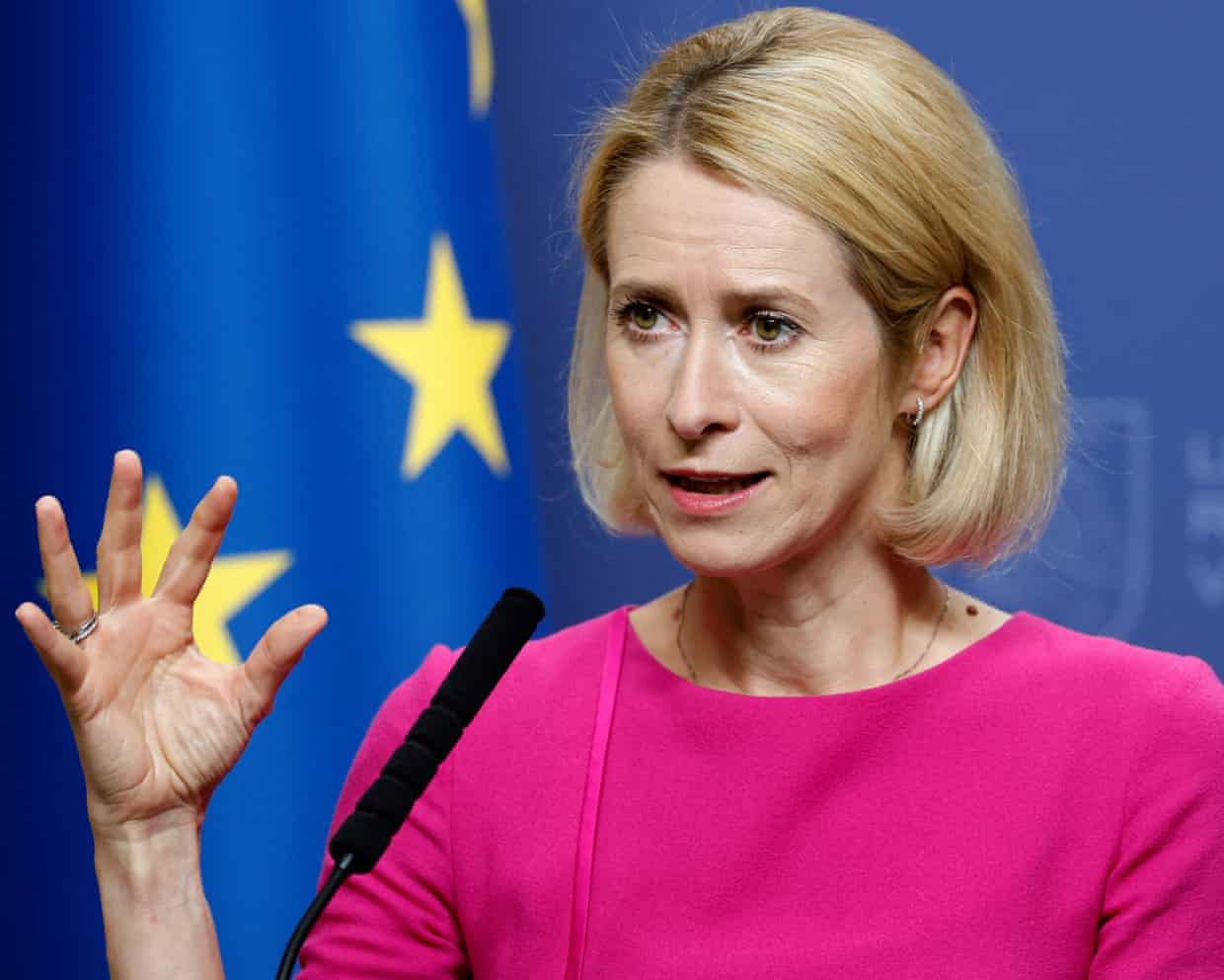 Kaja Kallas speaks at a podium during a press conference with a EU flag behind her