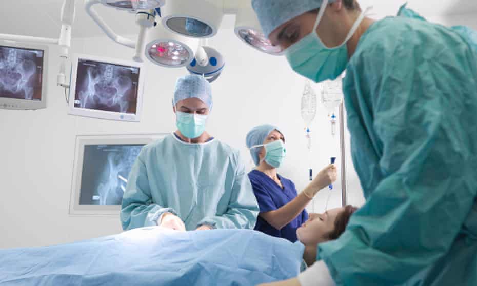 Surgeon and nurses performing surgery