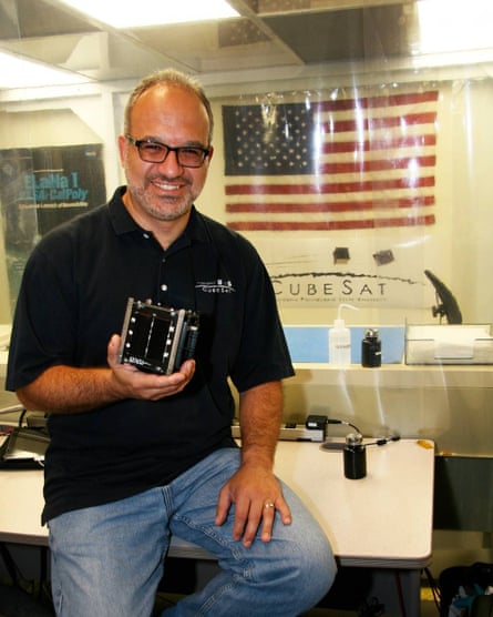 Jordi Puig-Suri is holding a cubesat, which he invented with Stanford Professor Bob Twigs.