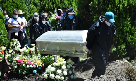 Cemetery workers wearing protective gear carry the plastic-wrapped coffin of a man who died from coronavirus at San Isidro cemetery, Mexico City.