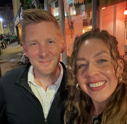 A selfie of Alex, with short blond hair, and Ellie, with curly blond hair, in a street at night