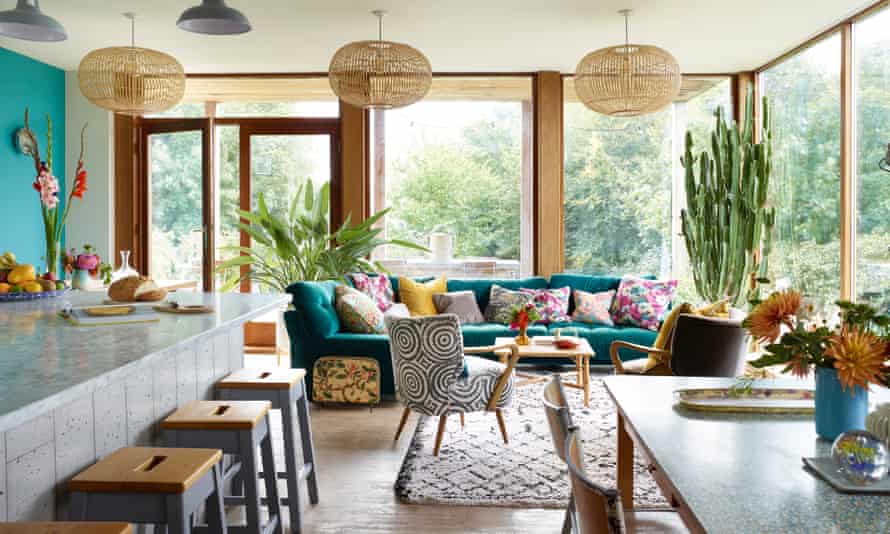 The extended dining room with two tables, colourful walls and views towards the coast.