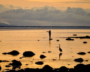 Willow Point, British Columbia, Canada ‘Two fishers at sunrise. The annual salmon run was in full swing near the Simms Creek and beach fishing by human fishers was as well. I was so focused on the fisher that only after seeing the photo did I notice the heron.’