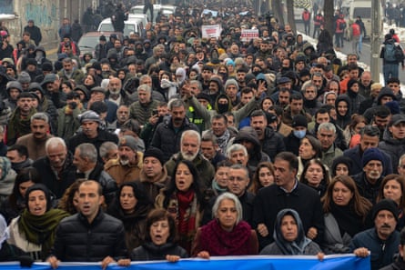 Crowd of protesters shout slogans as they walk along a road