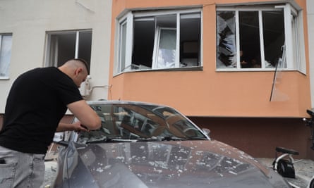 A man examines his car outside a damaged residential building in Odesa
