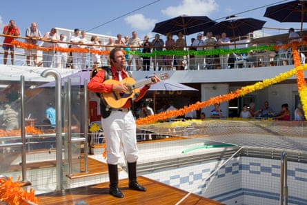 A Latin singer in mariachi style costume on a deck with onlookers