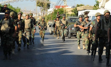Lebanese army soldiers patrol near the site of suicide attacks in the Christian village of al-Qaa.