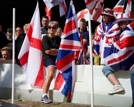 They sit on plastic barriers. Many are holding large union or St George’s flags