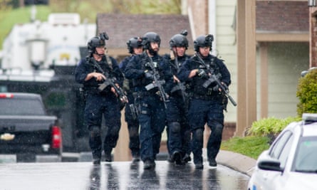 A Swat team and bomb squad serve a search warrant at the apartment of the suspected gunman.
