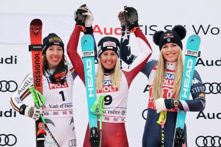 Austria's Cornelia Huetter celebrates on the podium after winning the women's downhill with second-placed Germany's Kira Weidle-Winkelmann and third-placed Lindsey Vonn.