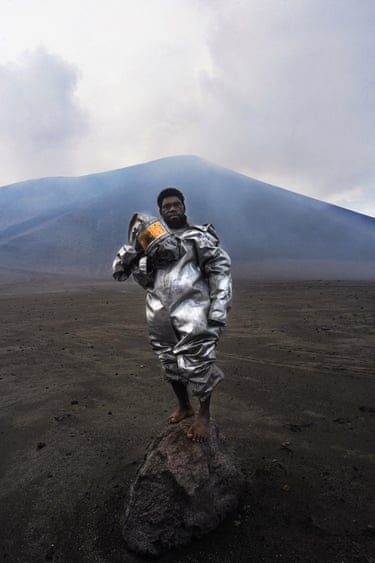 Phillip stands barefoot atop a volcanic rock bomb