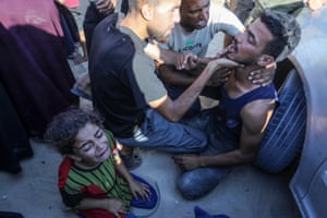 A child cries and adults comfort each other after their relatives were killed in Khan Yunis, Gaza