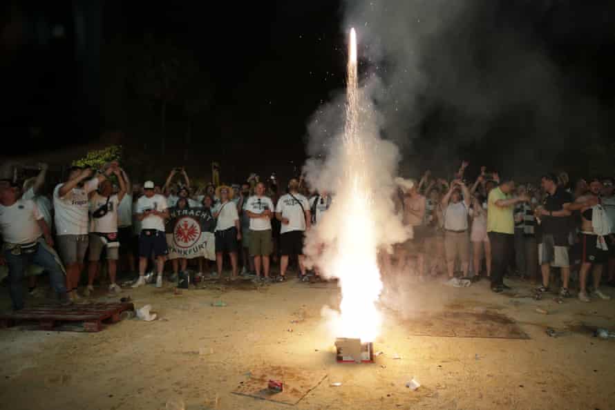 Eintracht Frankfurt supporters celebrate with a firework after their team equalised while watching the Europa League final on a screen in Seville.