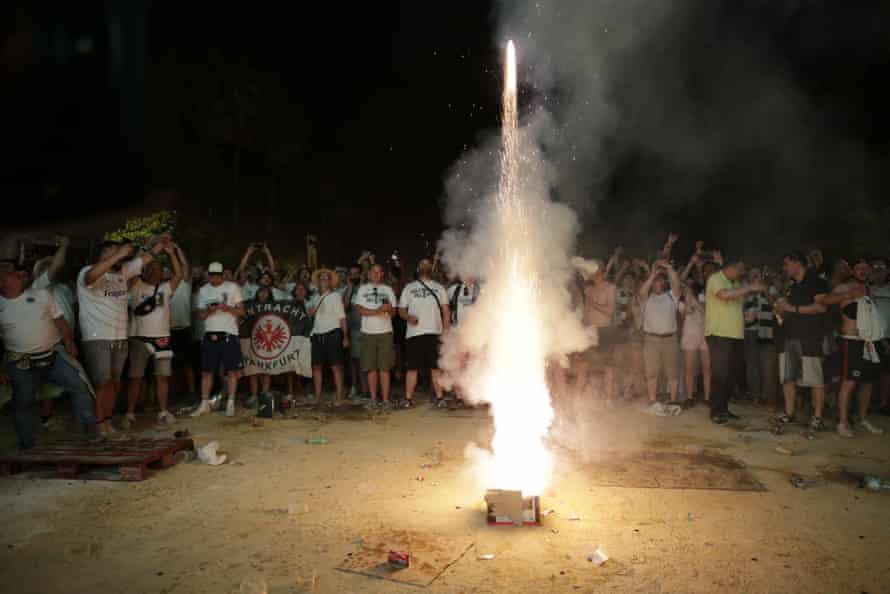 Eintracht Frankfurt v Rangers: Europa League final, extra time – live! | Europa League 10 Eintracht Frankfurt supporters celebrate with a firework after their team equalised while watching the Europa League final on a screen in Seville.