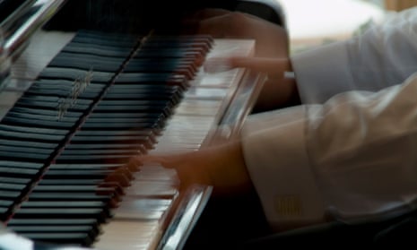 A player's hands speed over a piano keyboard