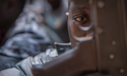 A newly released child soldier looks through a rifle trigger guard during a release ceremony for child soldiers in Yambio, South Sudan, in February 2018. More than 300 child soldiers, including 87 girls, have been released in the region of Yambio under a programme to help reintegrate them into society