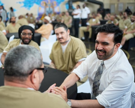 Mamdani shakes hands with a prisoner