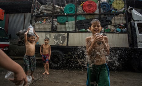 Children play with household plastic waste outside a sorting facility in Canumay West village in Valenzuela City, Manila, Philippines. 1 July 2019.