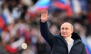 Russian President Vladimir Putin waves to the audience as he attends a concert marking the eighth anniversary of Russia's annexation of Crimea at the Luzhniki stadium in Moscow on March 18, 2022.