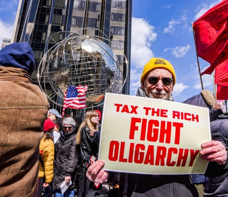 A demonstrator holds a sign reading tax the rich, fight oligarchy during a protest in Manhattan in March 2026