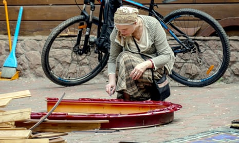 A woman cleans religious icons near a damaged church after a missile strike in Odesa.