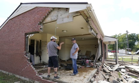 People look through a damaged home in Waverly, Tennessee, on 22 August. 