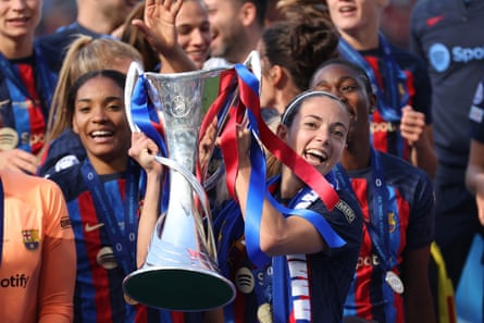 Aitana Bonmatí smiles a she lifts the Women’s Champions League trophy