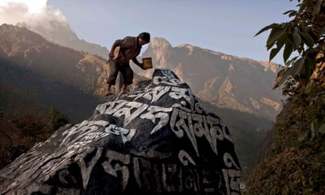 A Nepali Sherpa touches up the paint on a large Mani stone, which contains Buddhist prayers, near the village of Phakding, in Nepal.