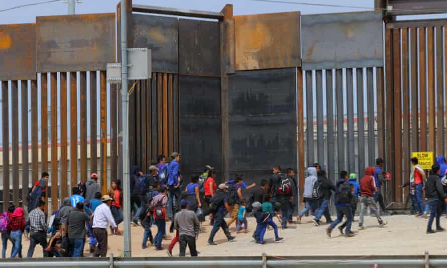 People approach a border post between the US and Mexico