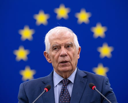 Josep Borrell standing in front of the EU flag