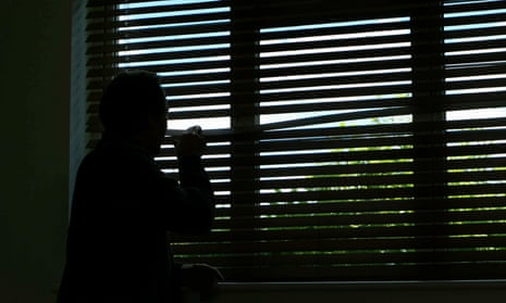 A silhouette of a boy looking out of a window.