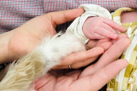 a woman holding a baby’s hand