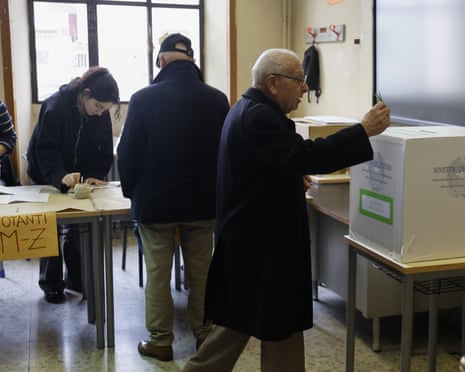 A voter casts his ballot at a polling station in Rome, Italy.