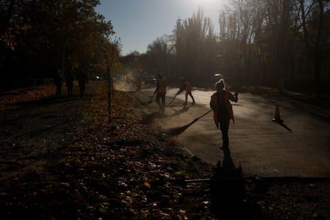 Municipal workers clean a street from debris left by a Russian missile attack in Mykolaiv earlier this morning.