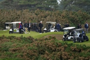 Donald Trump, his son and his son’s partner surrounded golf caddies and security personnel
