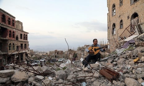 Yemeni artist sits atop the rubble